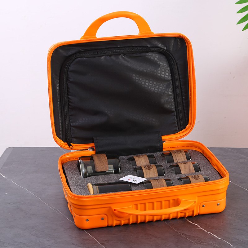 Travel tea set in an open mini hard-shell suitcase with foam interior